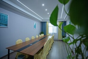 A conference room with a long table, chairs, and a plant. - Rujia Pebble Hotel (Baoying Anyi East Road, Baoying Yangzhou) (Baoying)