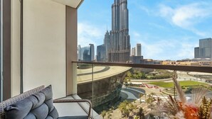 Een balkon met uitzicht op een modern wolkenkrabber en een aangelegde tuin.