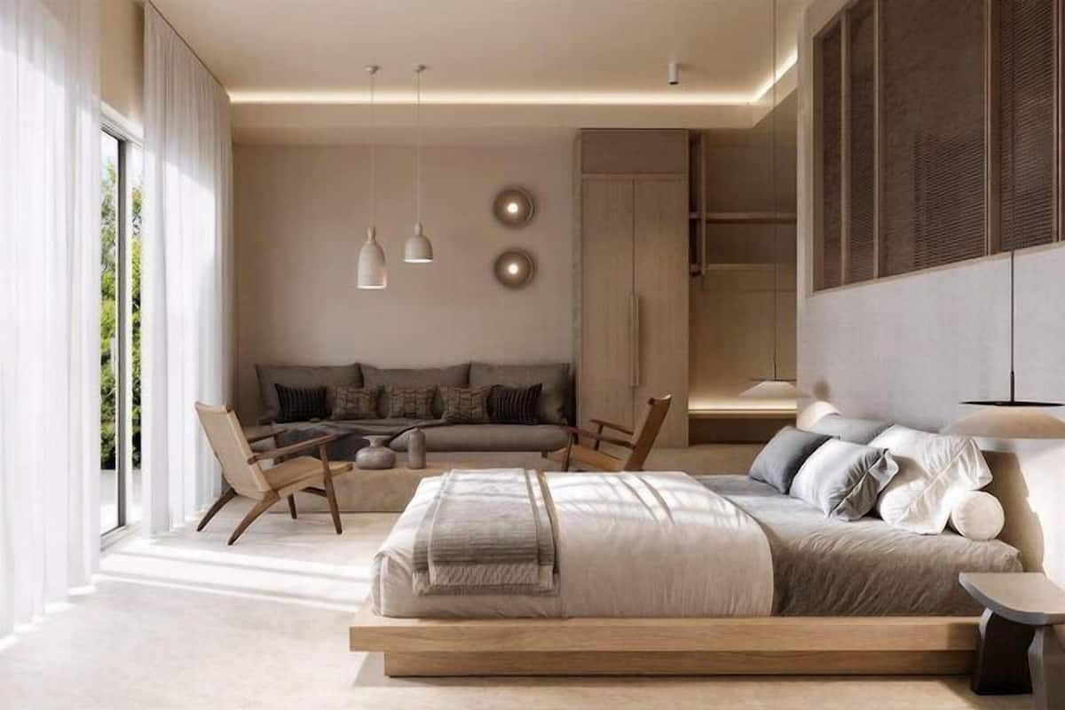Een moderne slaapkamer met een groot bed, een bank, een bureau en een stoel.