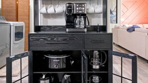 A compact kitchen with a coffee machine, a microwave, and a toaster.