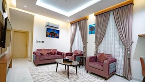 A modern living room with two sofas, a coffee table, and a TV. - Grand Season 3 (Al Khobar)