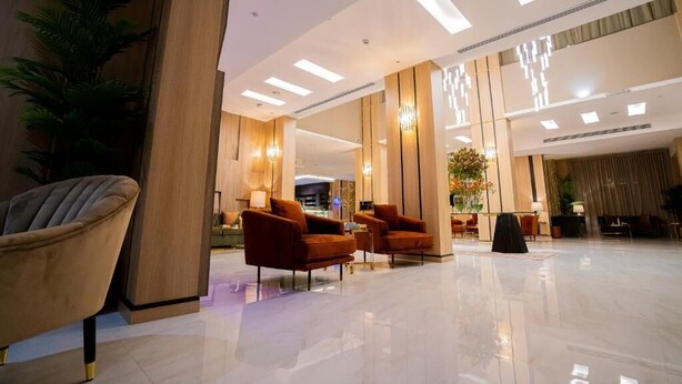 A modern lobby with a polished floor, wooden accents, and seating areas. - Grand Season 3 (Al Khobar)