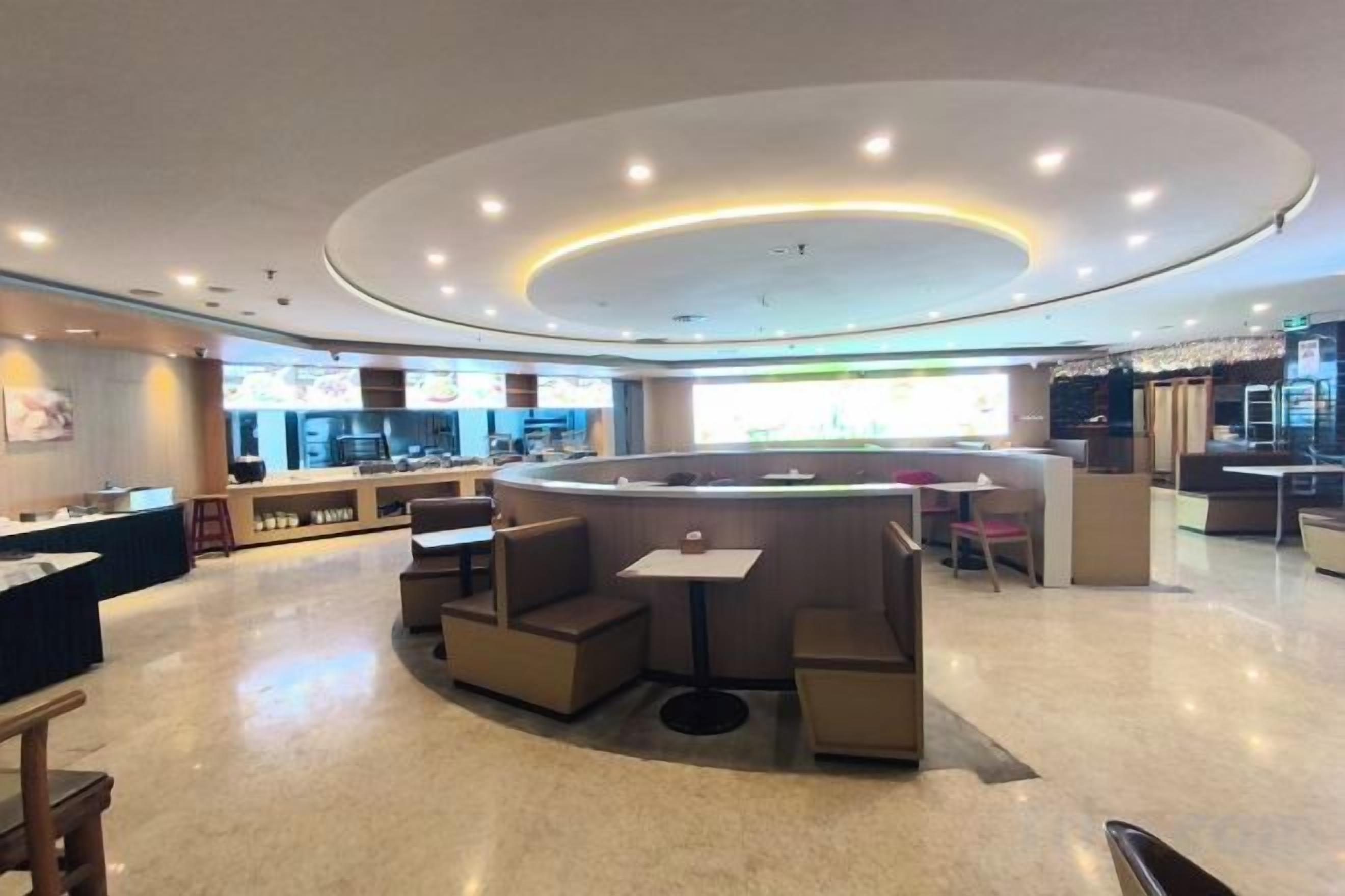 A modern interior with a central seating area, a counter, and a view of the kitchen.