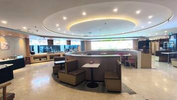 A modern interior with a central seating area, a counter, and a view of the kitchen.