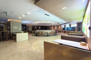 A modern hotel lobby with a central bar area, seating arrangements, and a reception desk. - Tangshan Magnolia Business Hotel (Convention Center University Road) (Tangshan)