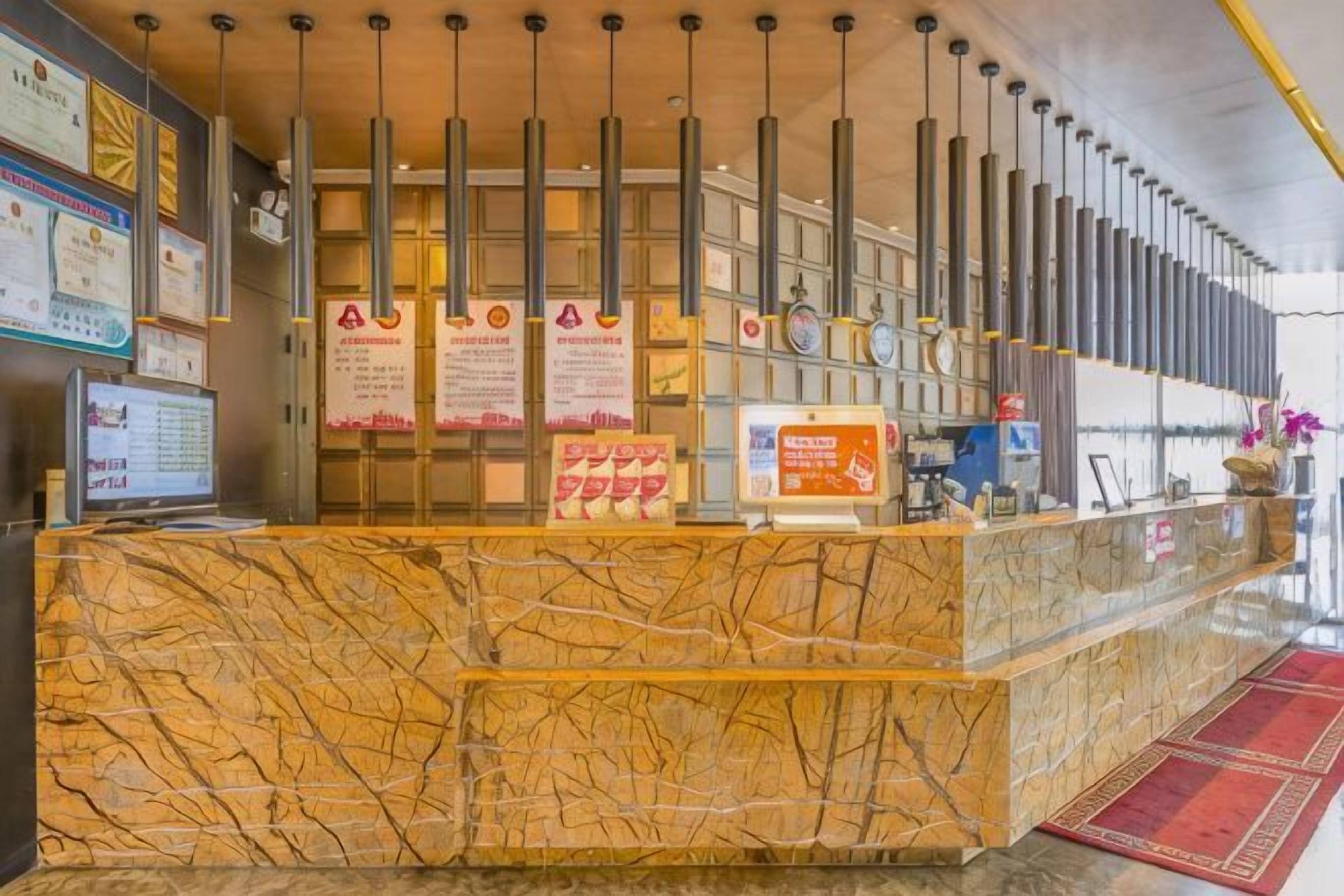 A reception desk with a marble top, vertical light fixtures, and informational signs.
