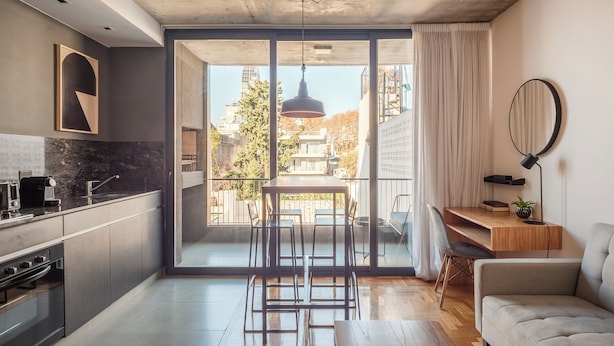 Une cuisine moderne avec un coin repas, de grandes fenêtres et une vue sur la ville.