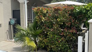 A residential building with a gravel driveway, a white car parked in front, and a lush green hedge. - Luxury villa (Armissan)