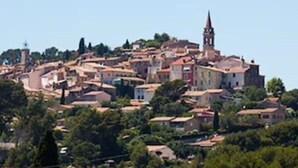 Une ville située sur une colline, avec des bâtiments historiques et un clocher d’église imposant.