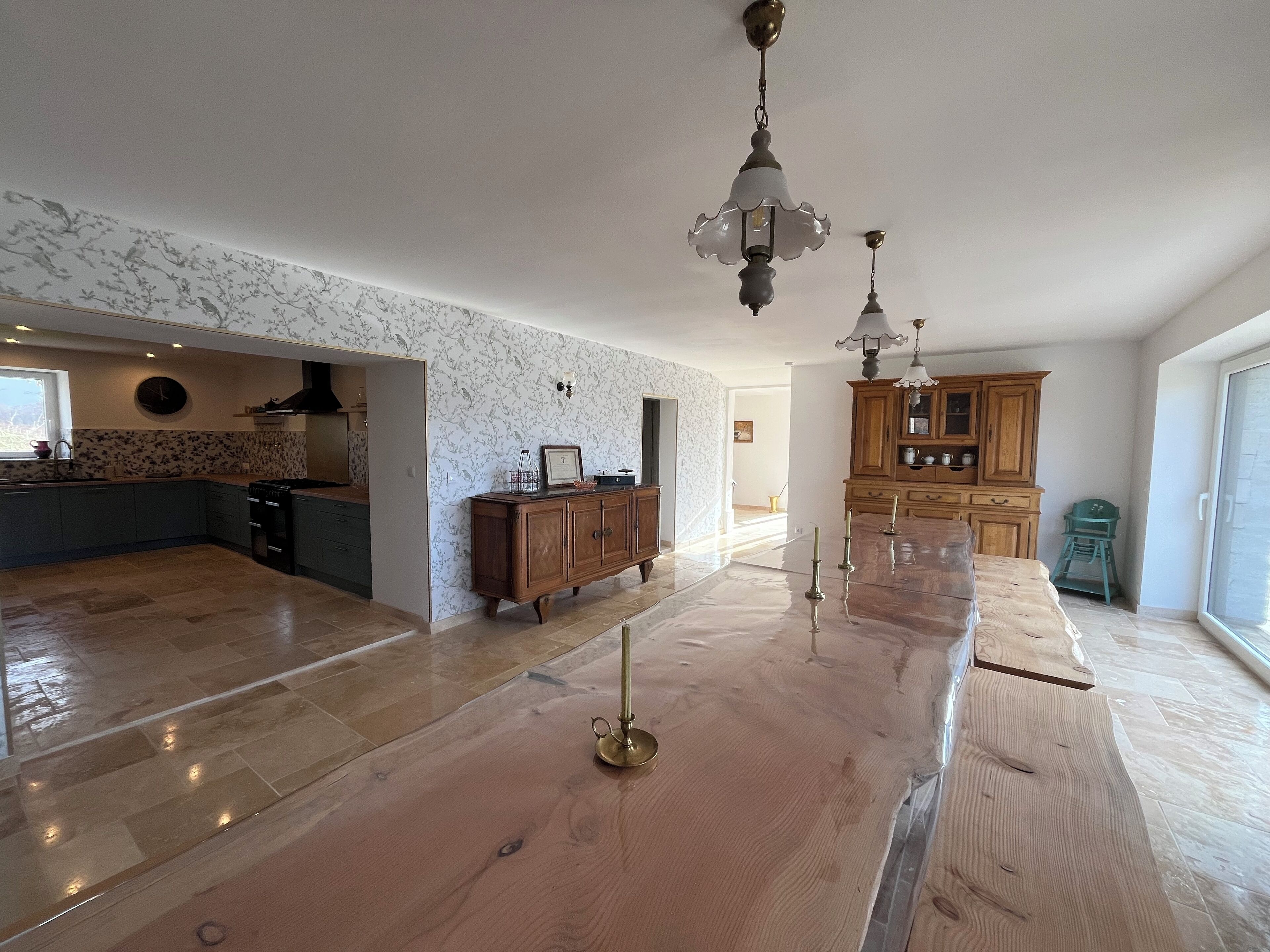 Una cocina amplia con una encimera de madera, un armario de madera y un candelabro.