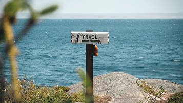 Un cartel indicador en la costa rocosa, con vista al mar.