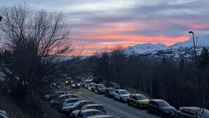 A parking lot with cars parked along a road, surrounded by snow-covered mountains and a sunset sky. - Studio 4 people Les Arcs 1600 (Bourg-Saint-Maurice)