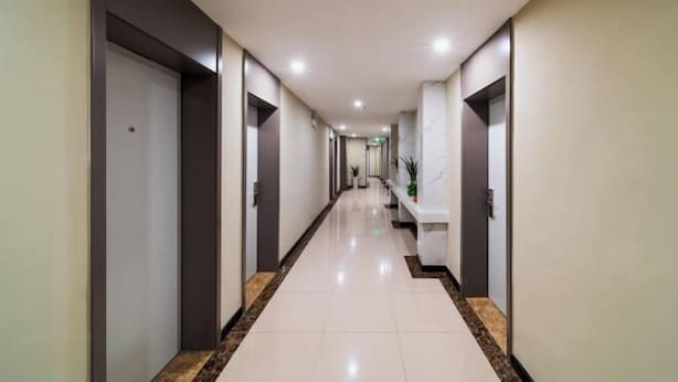 A long, narrow hallway with a marble floor and dark walls. - Home Inn Plus (Wuhan Chuhe Hanjie Metro Station Branch) (Wuhan)