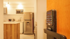Une cuisine moderne équipée d’un four à micro-ondes encastré, d’un réfrigérateur et d’une machine à café posée sur le plan de travail.