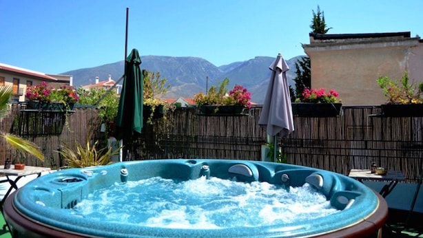 A hot tub in a backyard with mountains in the background. - Posada Alpujarra Sol (Orgiva)