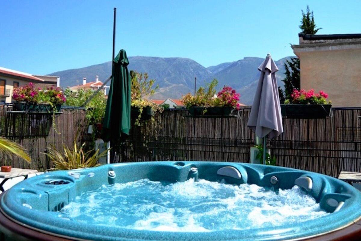 A hot tub in a backyard with mountains in the background.