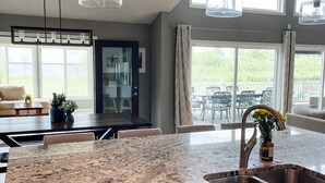 A kitchen with granite countertops, stainless steel appliances, and pendant lighting. - Luxurious Lakefront Escape – Premier EAA Rental with Breathtaking Views (Winneconne)