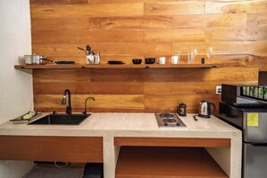 A kitchen with a wooden backsplash, a sink, a stove, and various kitchenware. - Private 1-Bedroom Suite in Cancún with Living Area (Cancún)