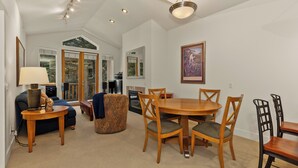 A spacious living area with a dining table, chairs, a sofa, and a fireplace. - Sun Valley 3BR - Hot Tub - 5min to River Run - Premium Snow Star Complex (Ketchum)