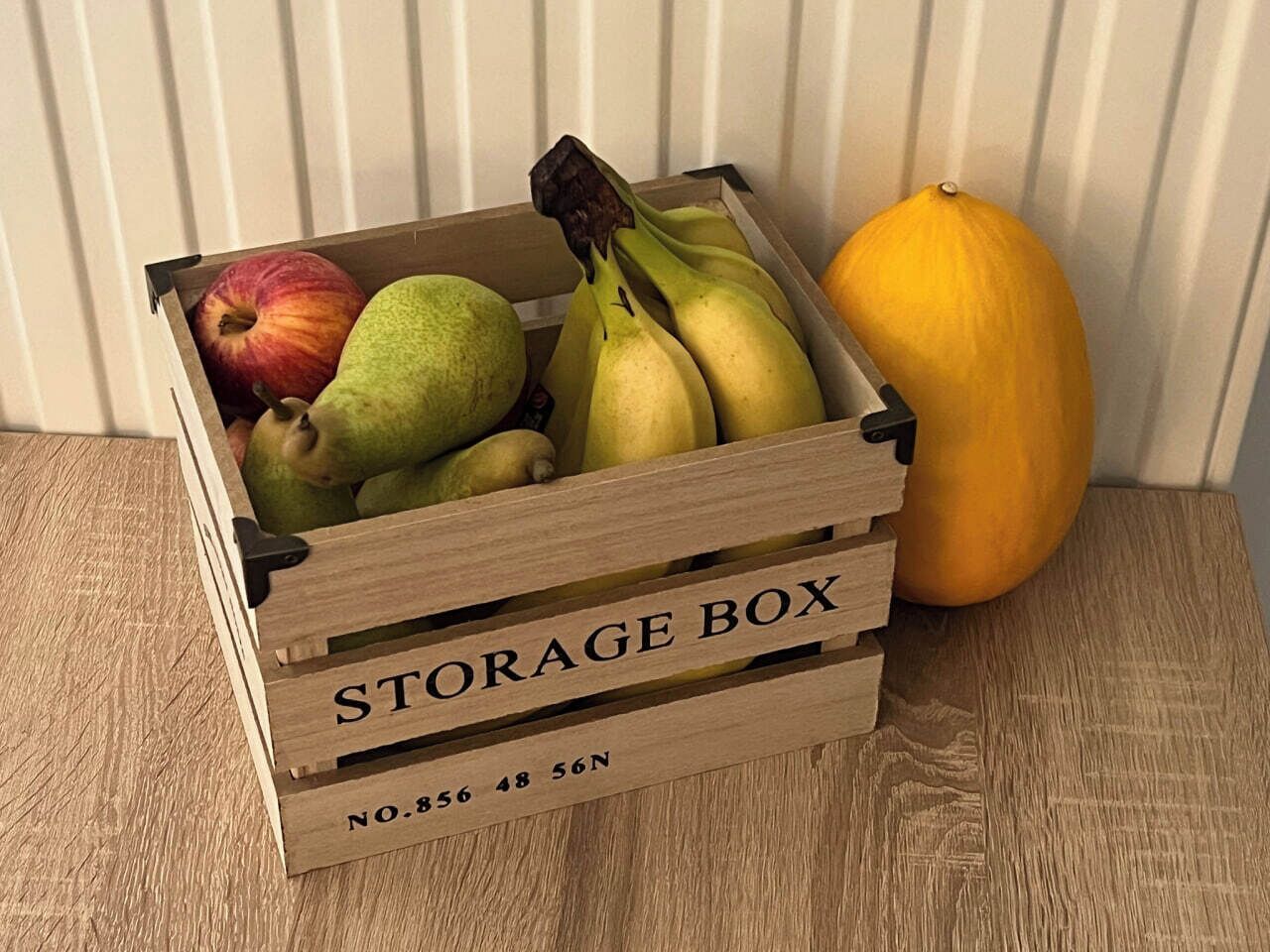 Eine hölzerne Aufbewahrungsbox mit der Aufschrift 'STORAGE BOX' und der Nummer 'NO.856 48 56N' auf einer Holzoberfläche.