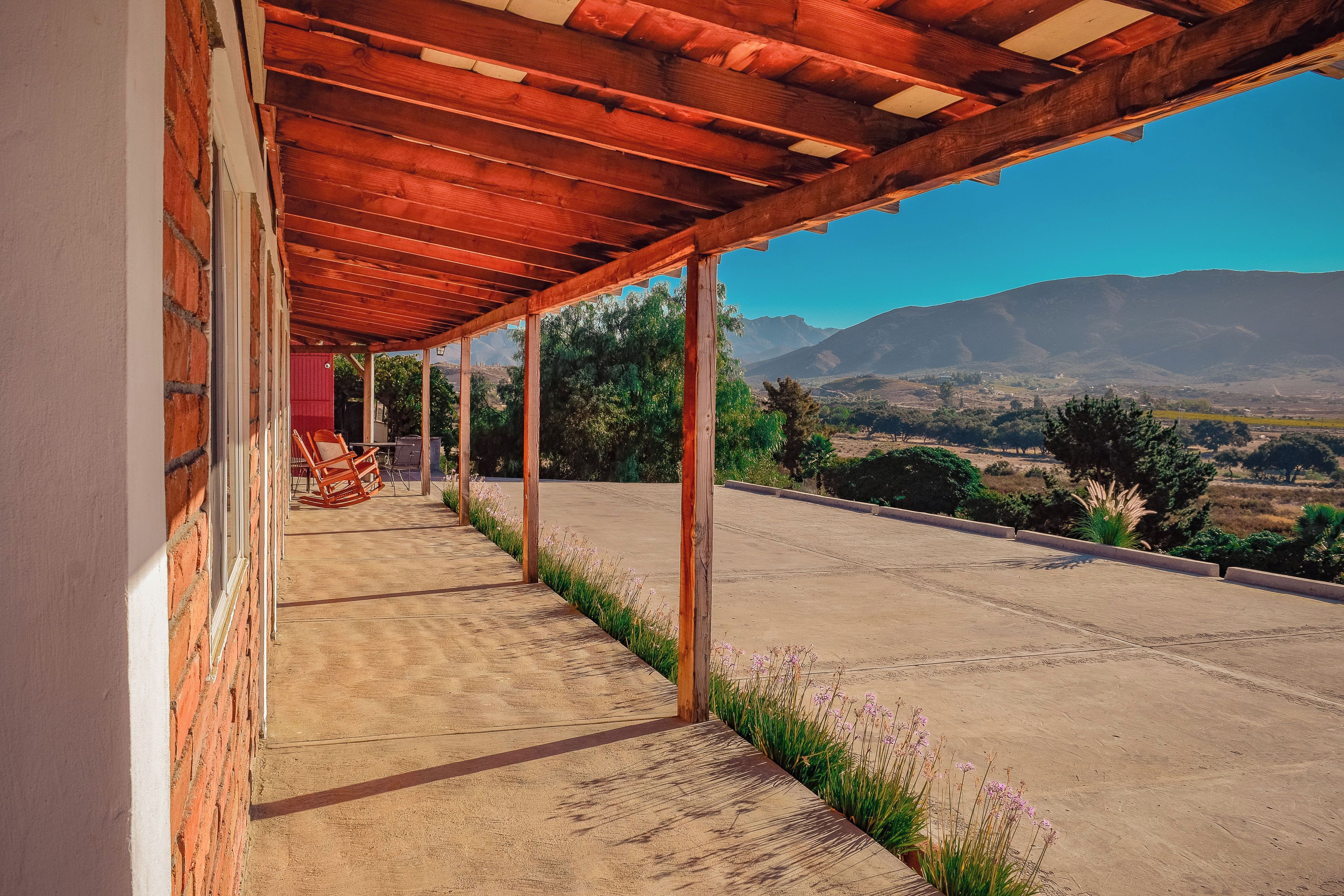 A covered outdoor area with a view of a mountainous landscape.