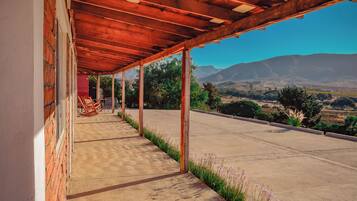 A covered outdoor area with a view of a mountainous landscape.