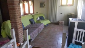 A room with a green sofa set, a small table, and a white chair. - Beautilful rustic country house totally imersed in the county of Marche (Marche)
