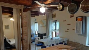 A dining area with a wooden table, chairs, and a ceiling fan. - Beautilful rustic country house totally imersed in the county of Marche (Marche)