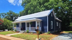 A single-story house with a porch, a mailbox, and a well-maintained lawn.