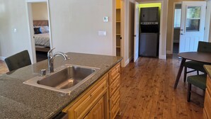 A kitchen with granite countertops, wooden cabinets, a stainless steel sink, and a built-in oven.