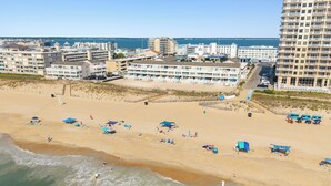 A beachside hotel with multiple buildings, a sandy beach, and a view of the ocean. - 5BR/4BA-Oceanview-Pool-Sundeck-Bike-Theater-Game Room-Sleep 16+ (Ocean City)