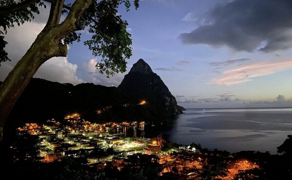 Watch the coastline glow as evening settles over the bay.