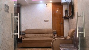 Una sala de estar moderna con un sofá, sillones, un televisor y una puerta de madera.