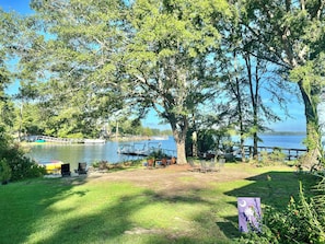 A lakeside view with a dock, grassy area, and picnic table. - Mystic Shores on Lake Murray (Gilbert)