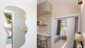 A modern kitchen with a white countertop, a bar stool, and a built-in bench. - Kalamata Cozy Nest With Panoramic Views (Kalamata)