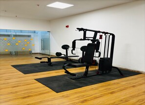 A gym with exercise equipment, wooden flooring, and a glass wall with hexagonal patterns. - Housr Sector 28 Gurgaon Near IFFCO Chowk (Gurugram)