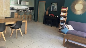 Un espace de vie moderne comprenant un coin repas, une cuisine et un coin salon.