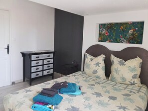 A bedroom with a bed, a dresser, and a painting on the wall. - Farmhouse in the heart of nature, for 10 people with heated swimming pool (Laroque)