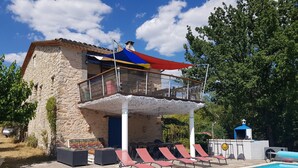 Ein Gebäude aus Stein mit Balkon und Poolanlage.