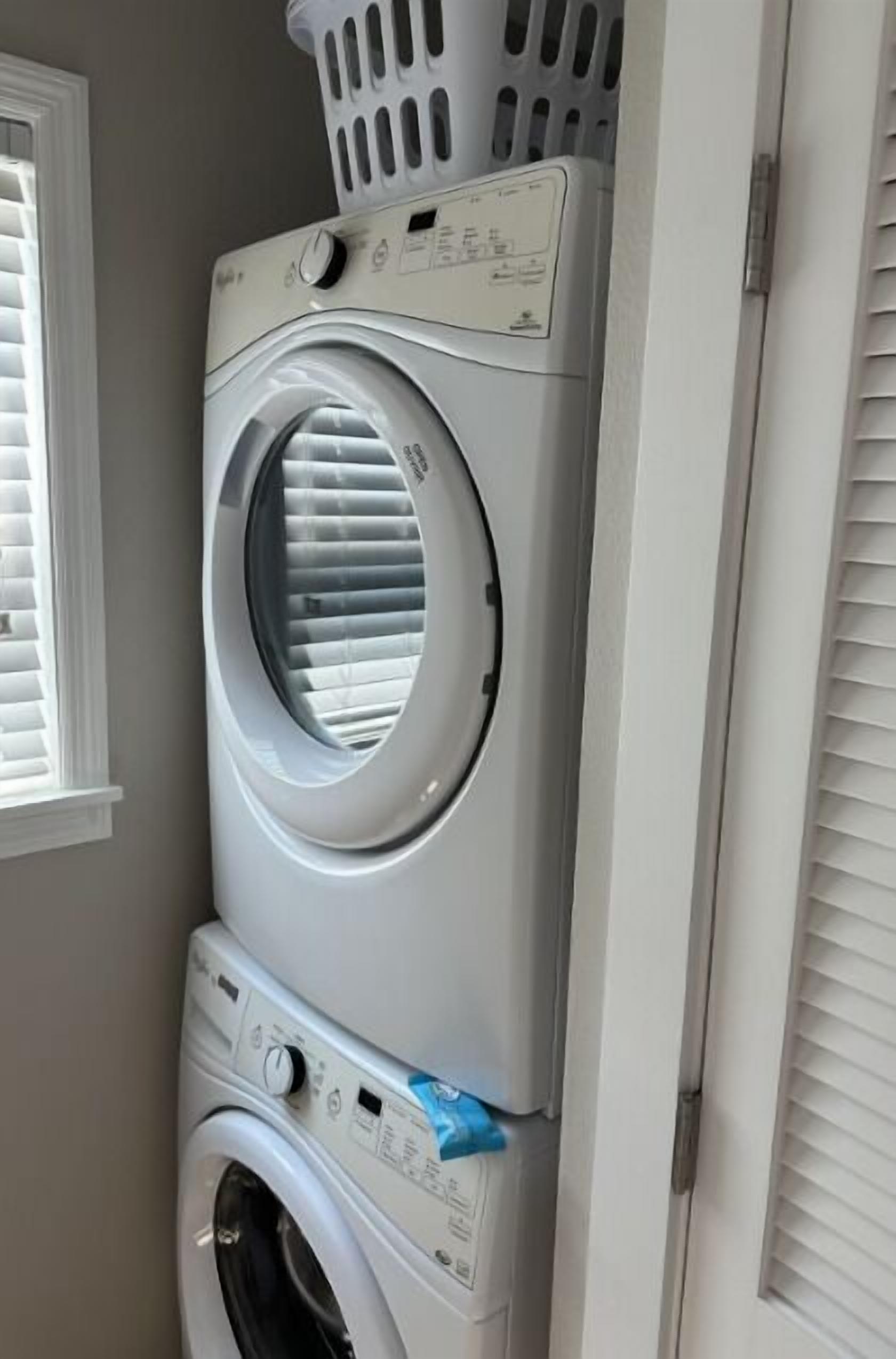 Una lavadora y secadora apiladas en un cuarto de lavado.