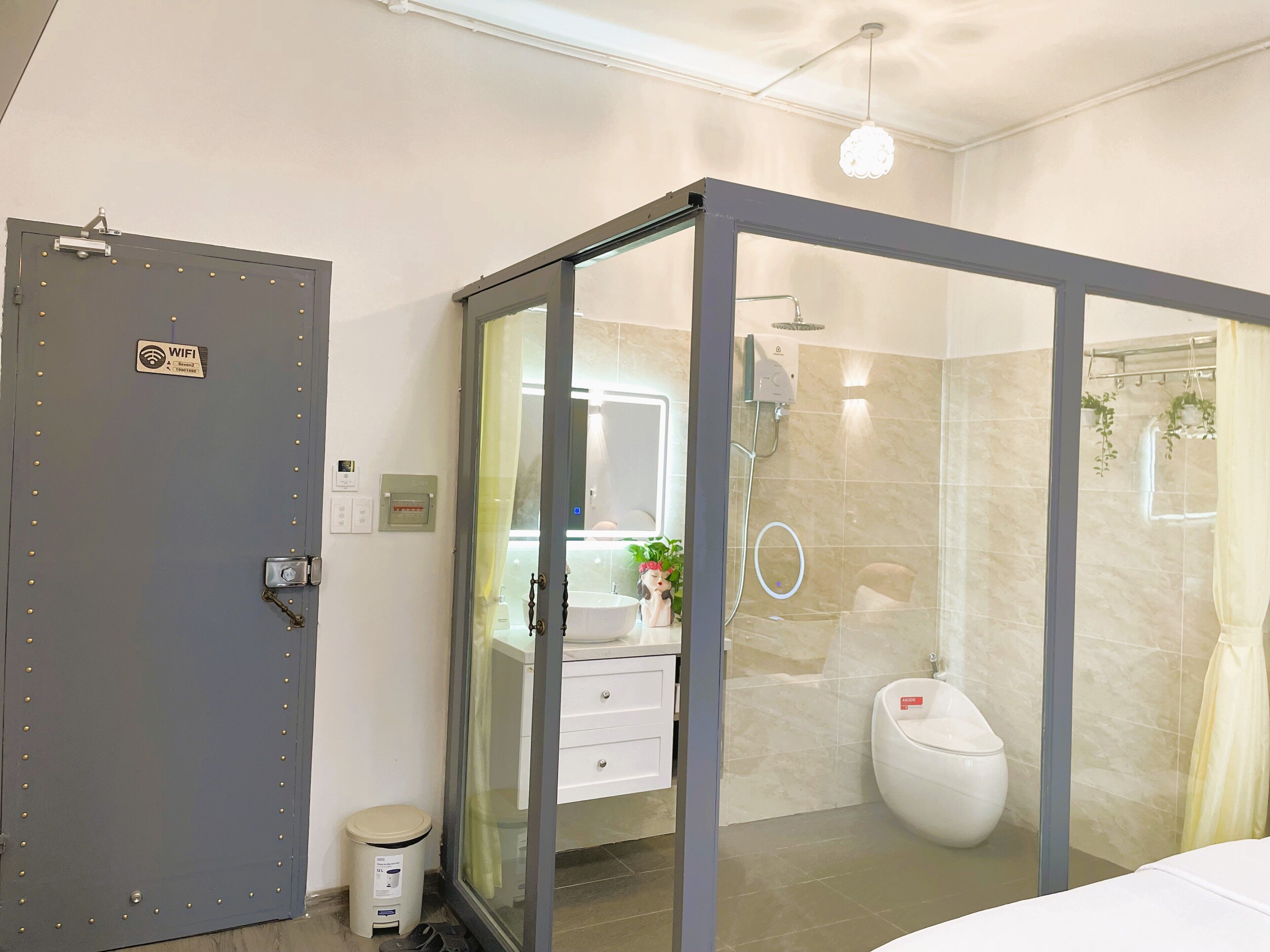 A modern bathroom with a glass-enclosed shower, a toilet, and a sink with a mirror.