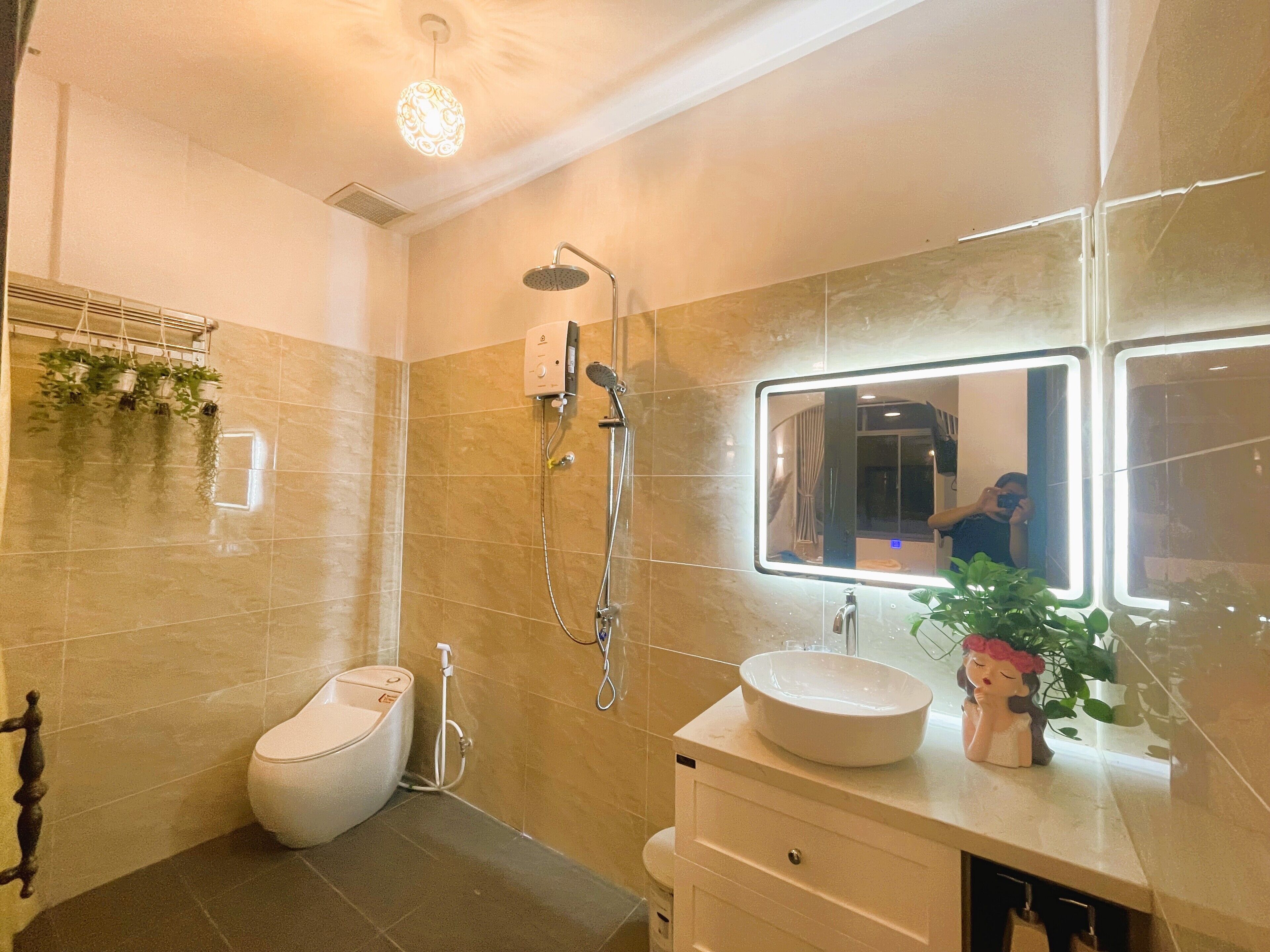 A modern bathroom with a shower, toilet, and sink.