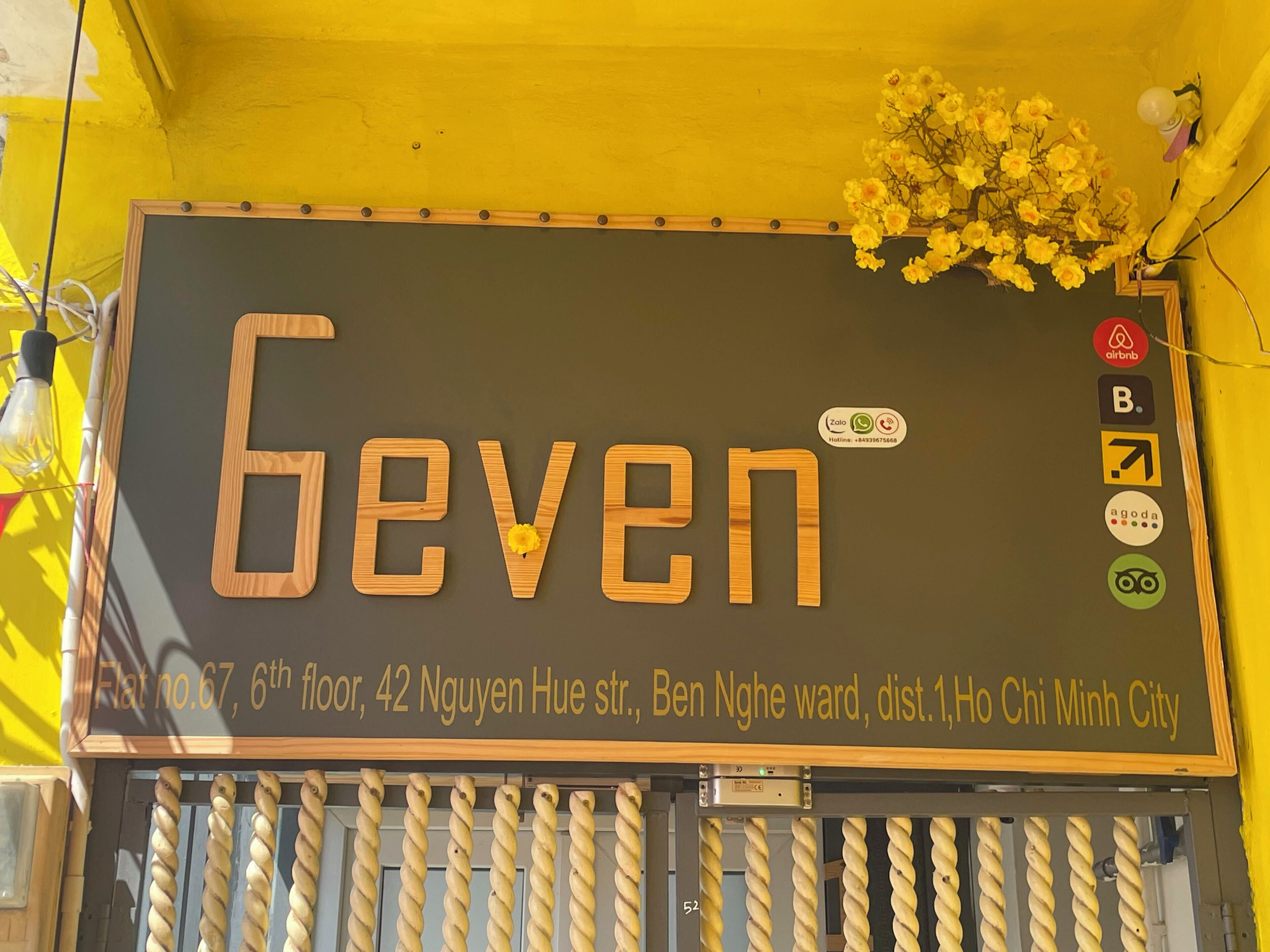 Une pancarte avec le mot « Seven » et une composition florale.