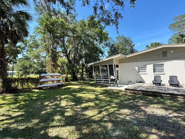 A modern house with a covered patio, a barbecue area, and a screened porch.