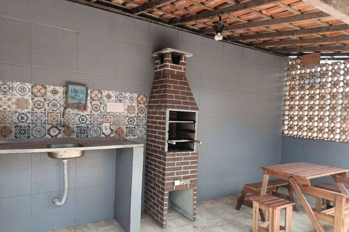 Un horno de ladrillo al aire libre, un revoque de azulejos y una mesa de madera con bancos.