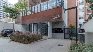 Ein modernes Gebäude mit der Hausnummer 1046, ausgestattet mit einem Glastürrahmen und einem kleinen Garten.