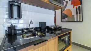 Eine moderne Küche mit schwarzem Arbeitsplatz, Spüle aus Edelstahl und eingebautem Backofen.