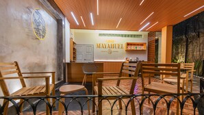 L’intérieur d’un restaurant est aménagé avec des meubles en bois, un comptoir d’accueil et un sol carrelé.