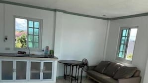 A spacious living area with a kitchenette, a sofa, and a dining table. - Casa Solana (calmar, lucena city)