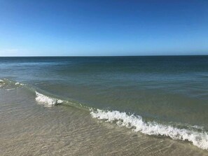Une plage à l’eau claire et à la mer calme.